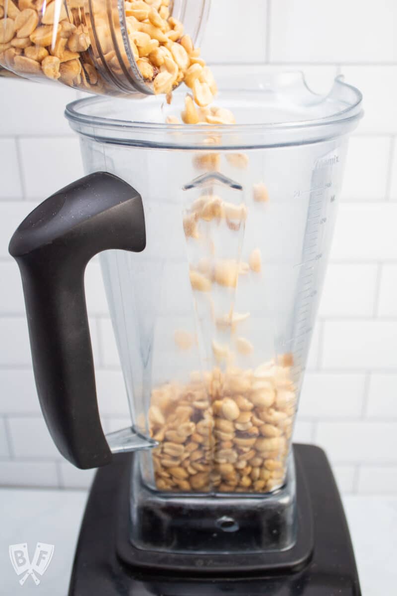 Pouring peanuts into a blender.