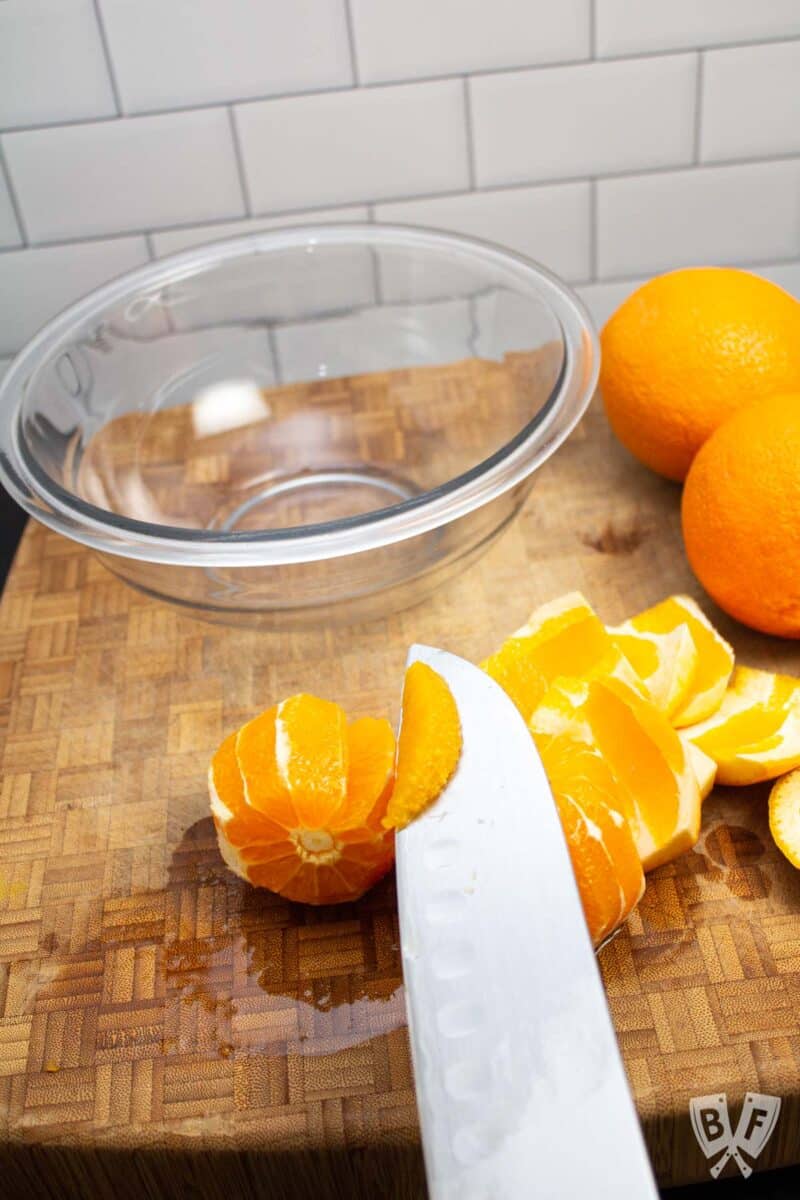 Knife removing segments from an orange.