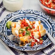 Plate of taquitos with pico de gallo and lime crema.