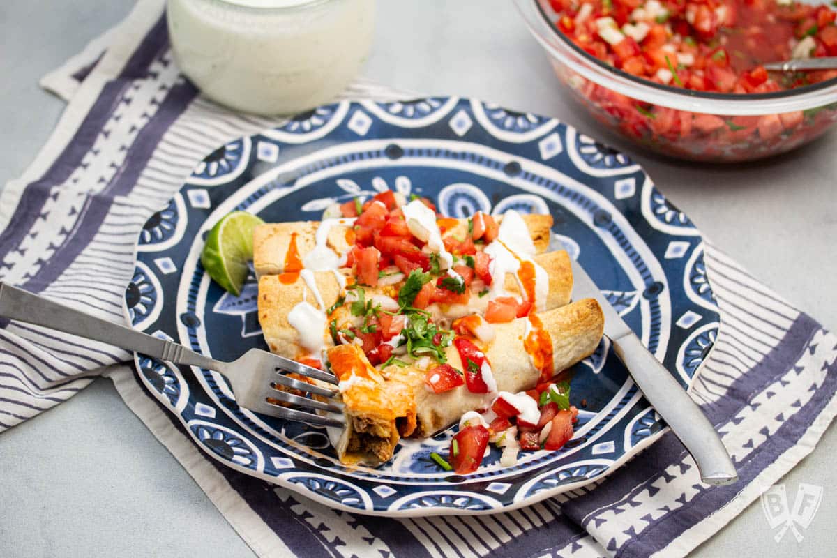 Plate of taquitos with pico de gallo and lime crema.