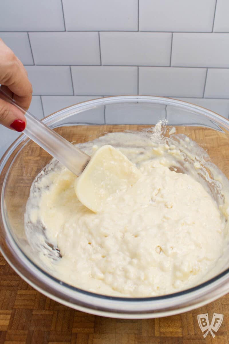 Mixing together pancake batter in a bowl.