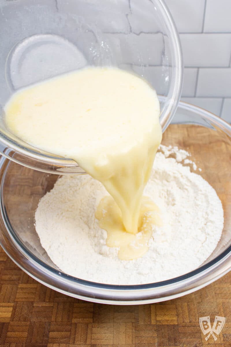 Pouring the wet ingredients into the dry ingredients for birthday cake pancakes.