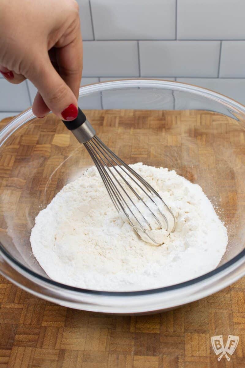 Whisking together dry ingredients for funfetti pancakes in a bowl.