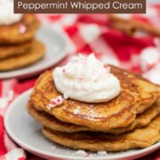 Stack of gingerbread pancakes with peppermint whipped cream and crushed peppermint candies. Text reads. "Gingerbread Pancakes with Homemade Peppermint Whipped Cream".