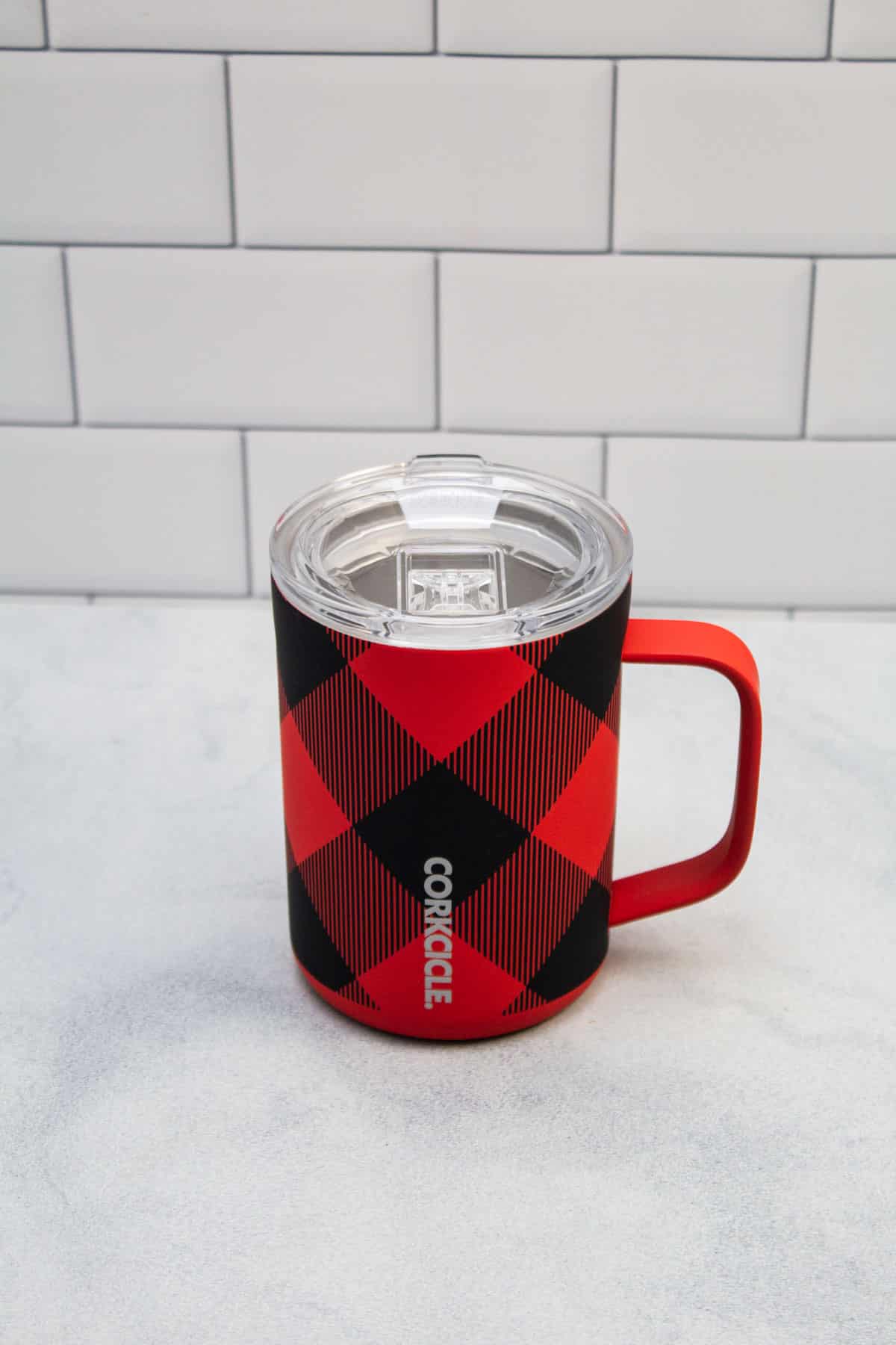 Insulated plaid patterned coffee mug with lid.