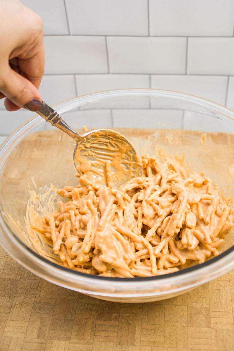 Stirring together the ingredients for butterscotch haystacks in a mixing bowl.