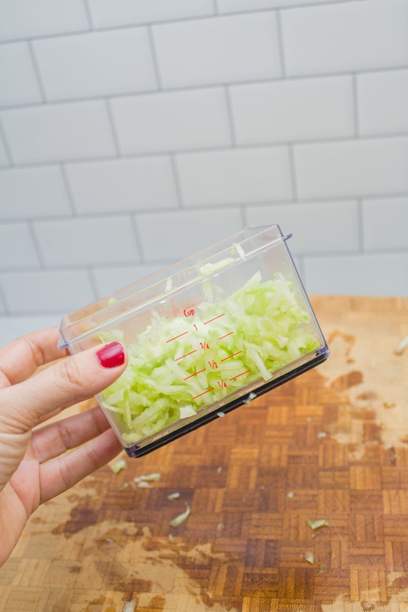 Measuring cup full of grated cucumber.