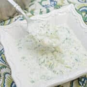 Spoonful of cucumber raita in a bowl.