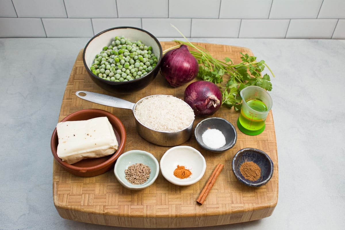 Ingredients ready to make Indian pullao with basmati rice, paneer cheese, red onions, and spices.