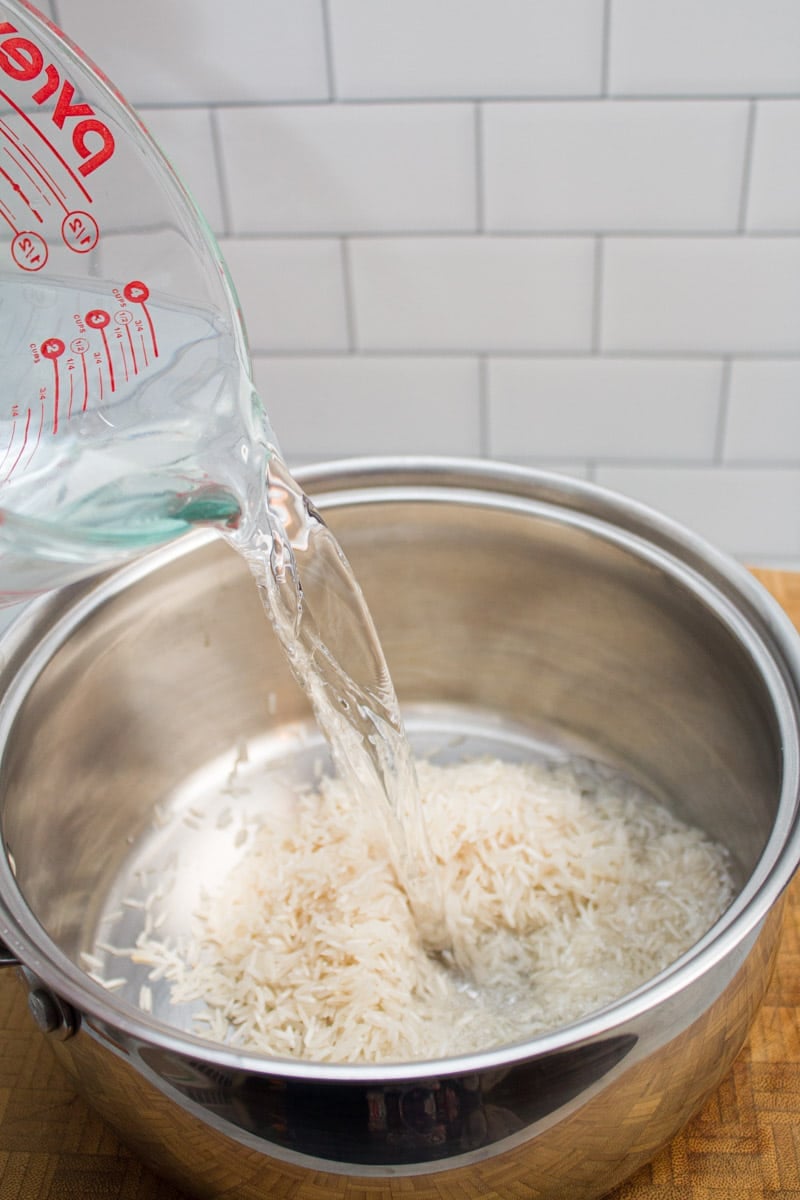Pouring water into a pot with rice.