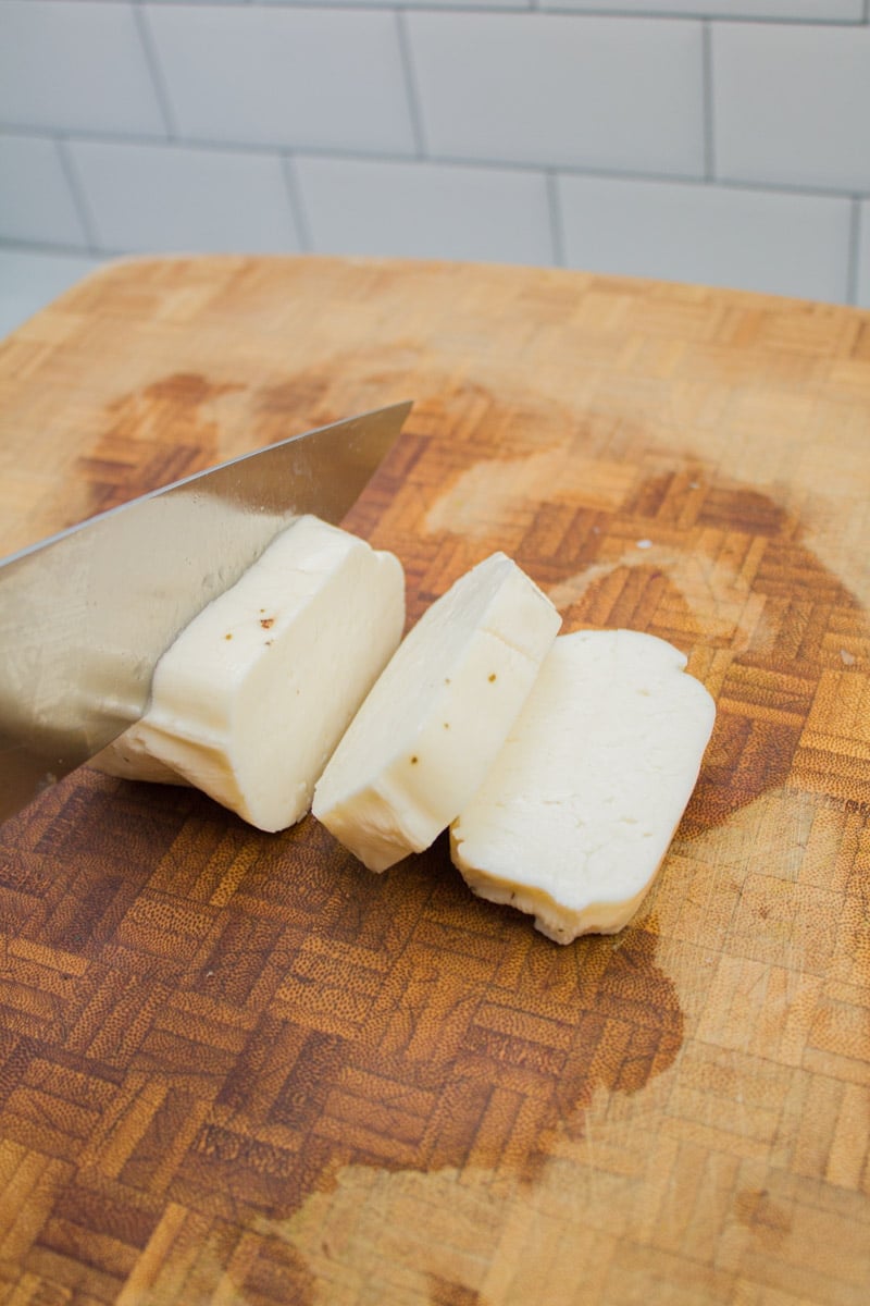 Cutting paneer cheese into cubes.