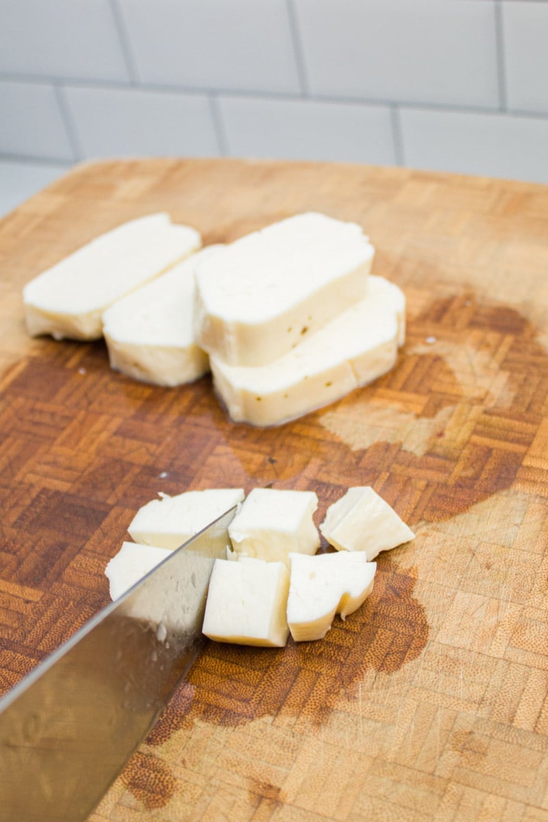 Cutting paneer cheese into cubes.