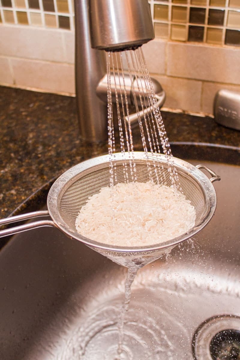 Rinsing rice in a strainer.