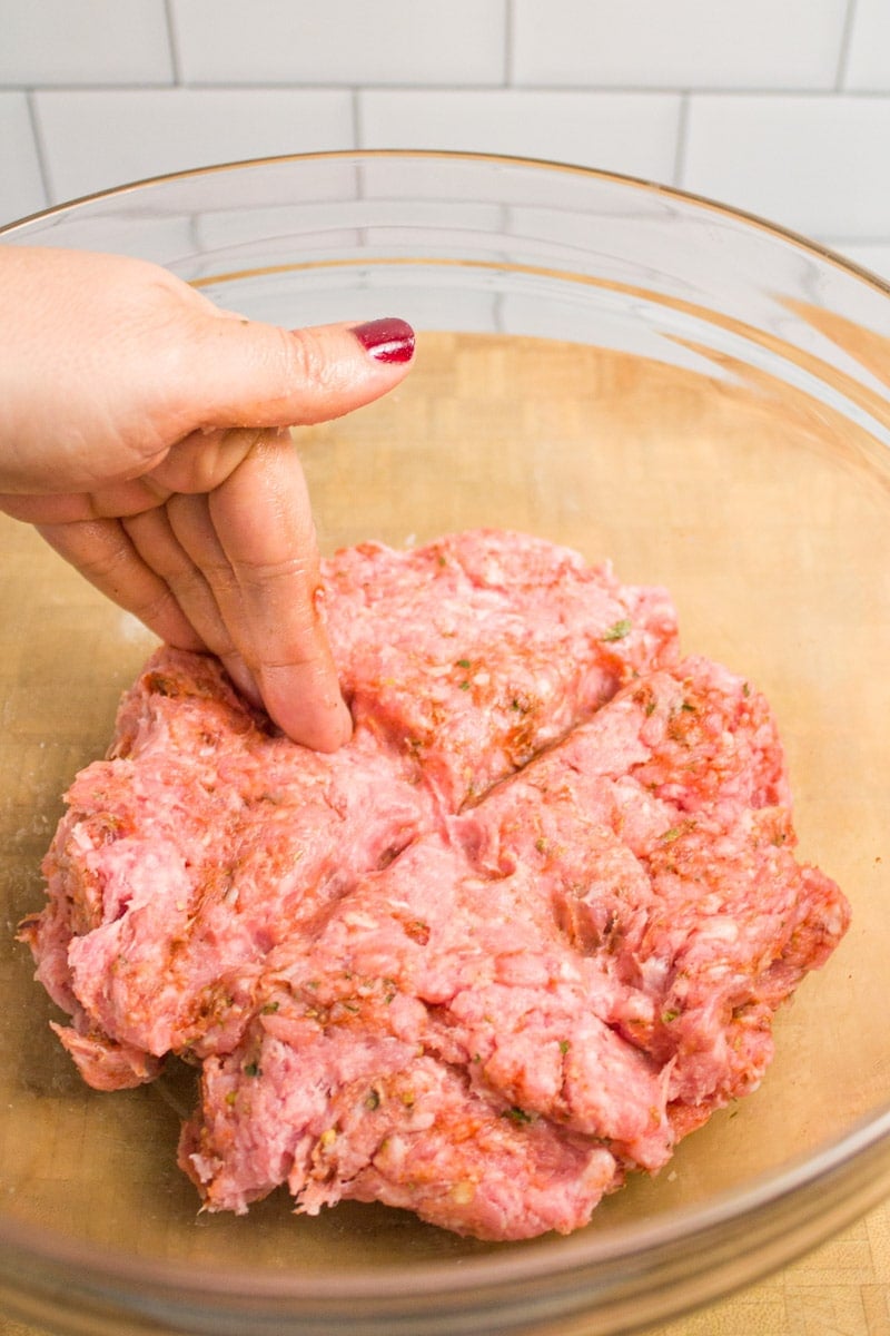 Dividing ground pork mixture to make breakfast sausage patties.