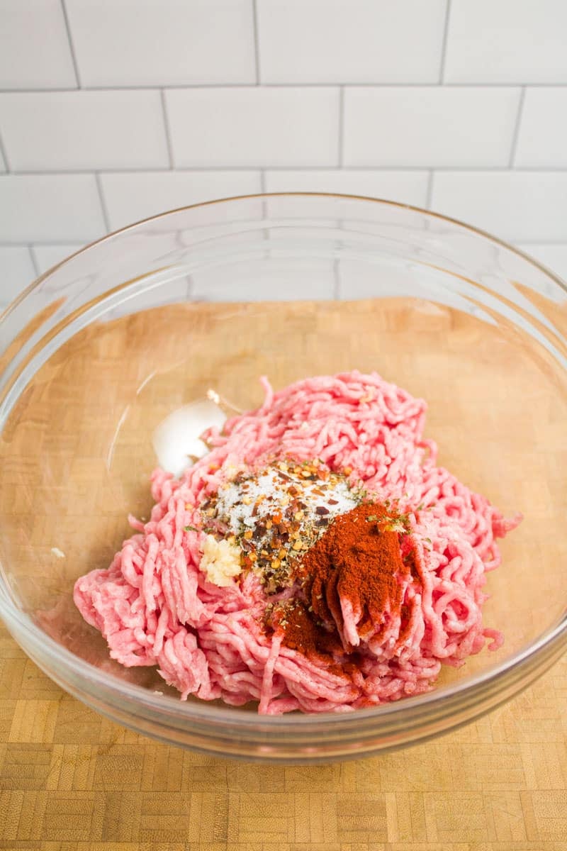 A bowl of ground pork and spices ready to form into breakfast sausage patties.