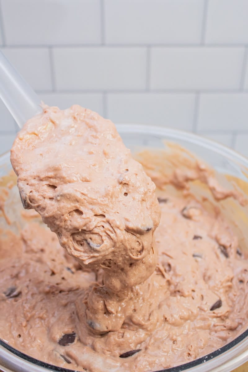 Stirring chocolate chips into a chocolate pancake batter.