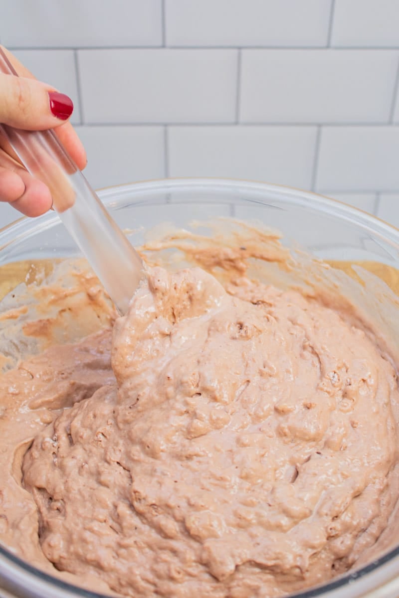 Stirring wet ingredients into dry ingredient for chocolate chocolate chip pancakes.