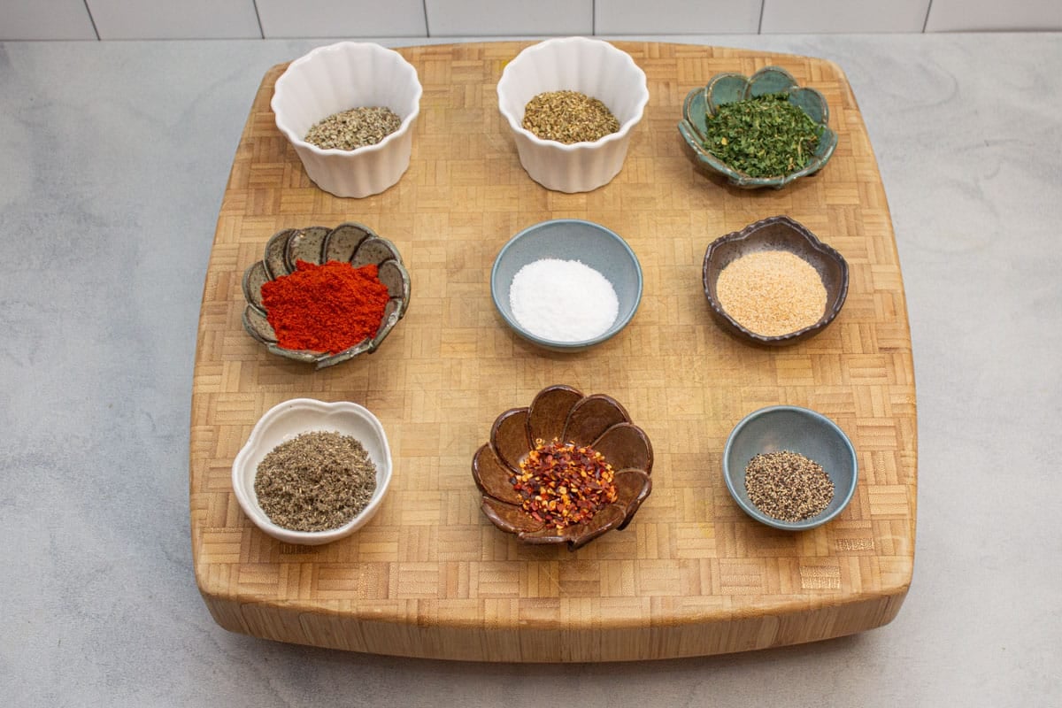 Small bowls of spices ready to make a breakfast sausage seasoning mix.