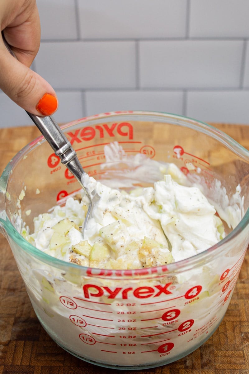 Stirring together ingredients for homemade tzatziki.
