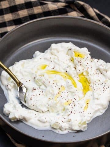 Bowl of tzatziki with olive oil drizzled over the top.