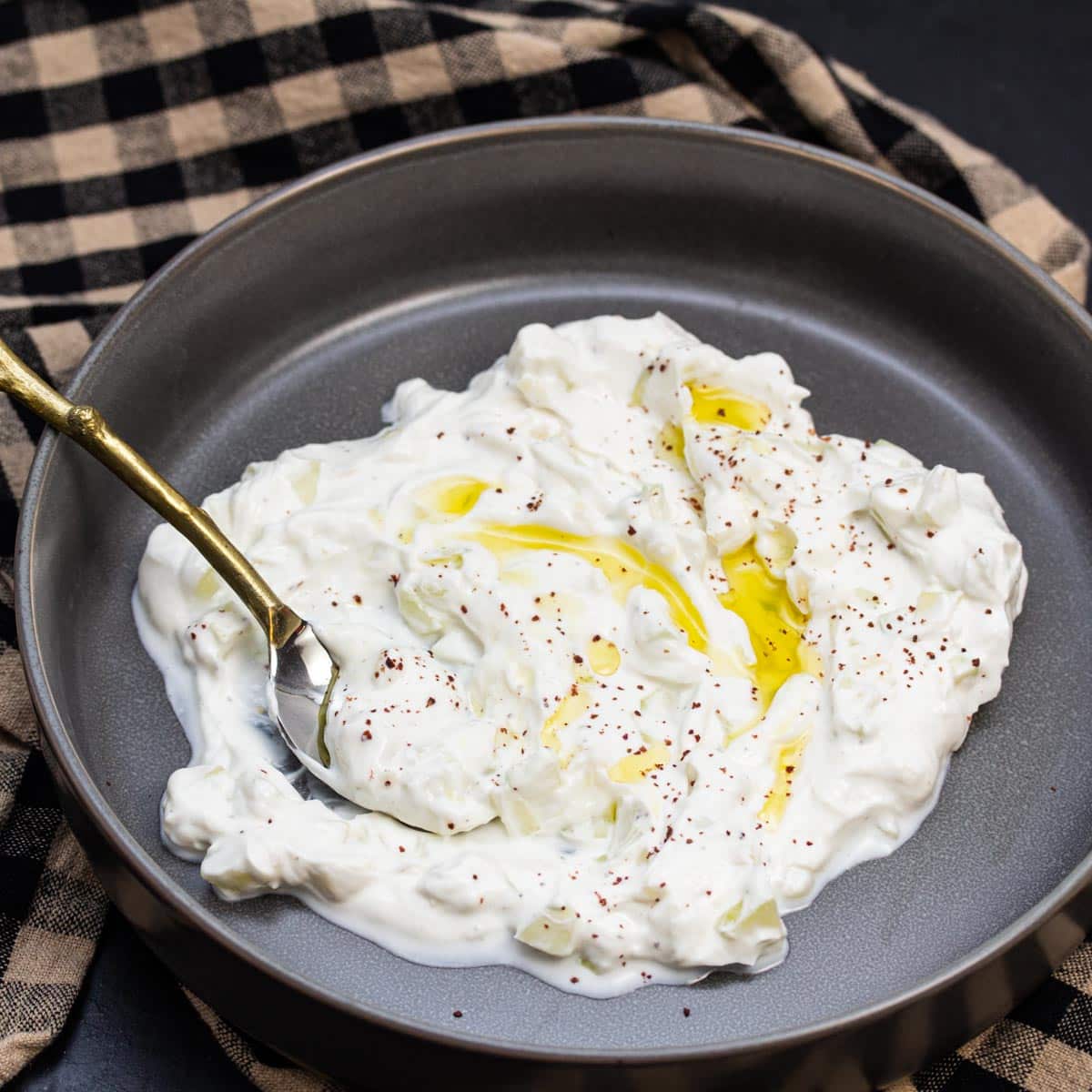 Bowl of tzatziki with olive oil drizzled over the top.