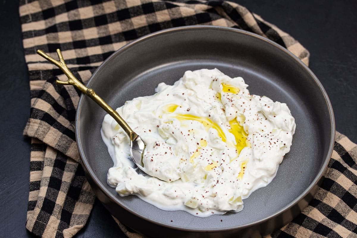 Bowl of tzatziki with olive oil drizzled over the top.