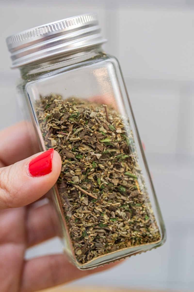 Holding a jar of homemade Italian seasoning blend.